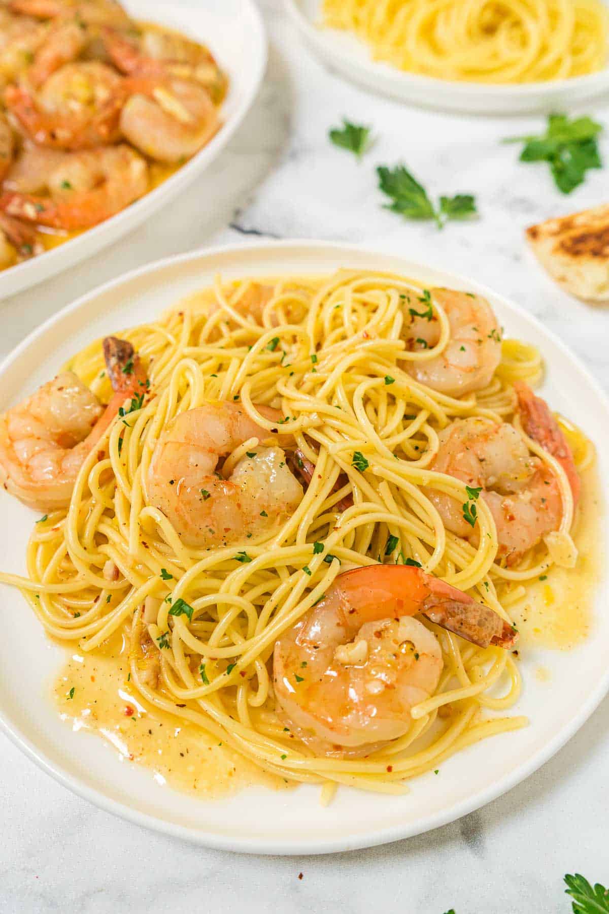 A plate of shrimp scampi served with pasta.