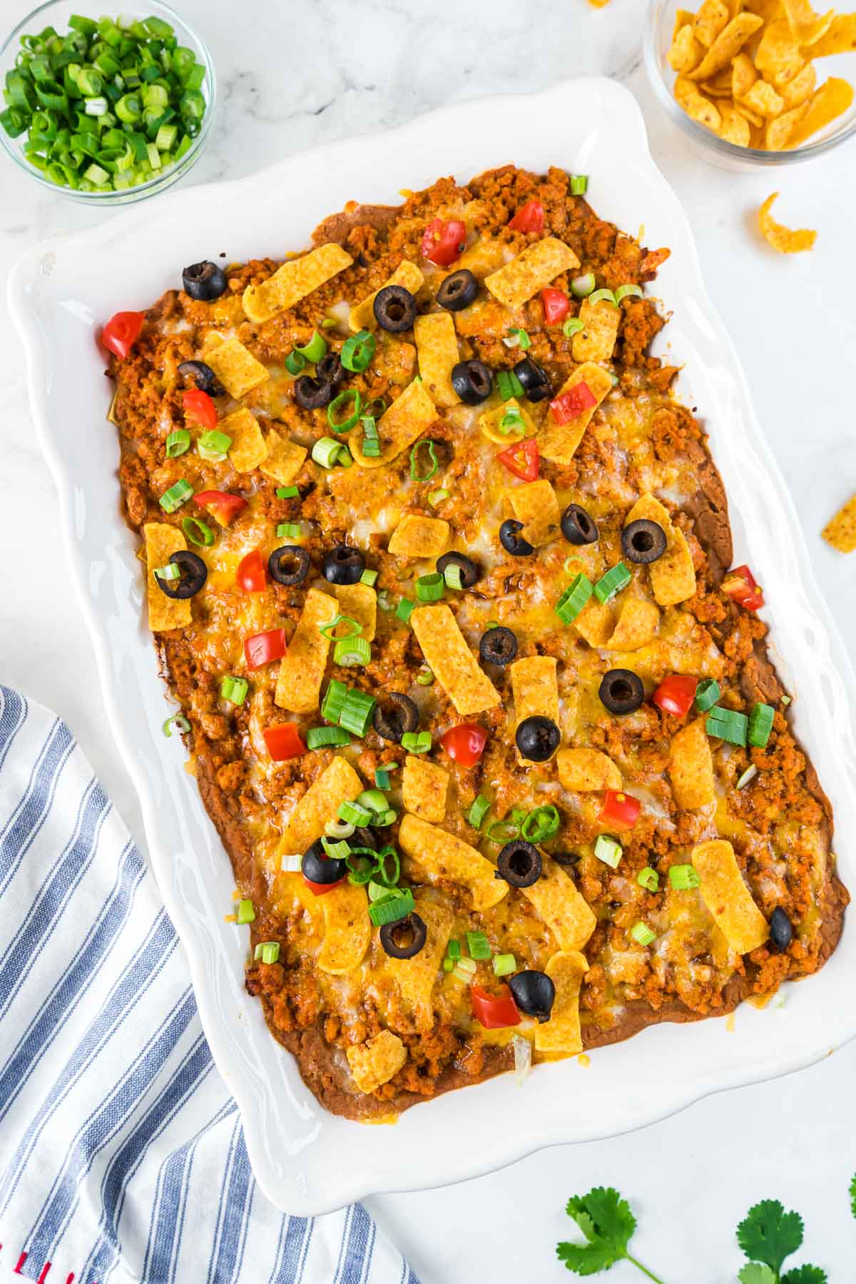 Easy Turkey Taco Casserole in a white baking dish with lots of taco toppings. 