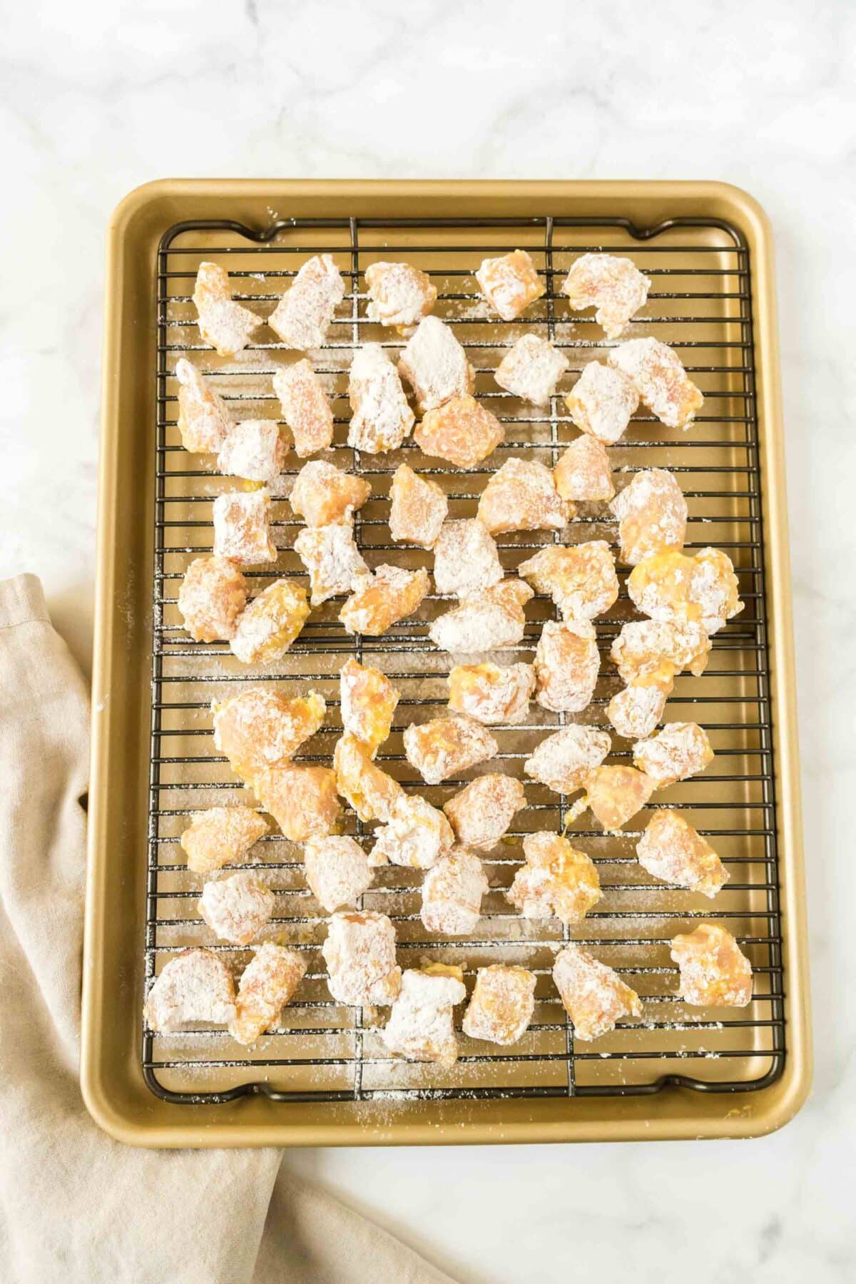Pieces of breaded chicken on a cooling rack.