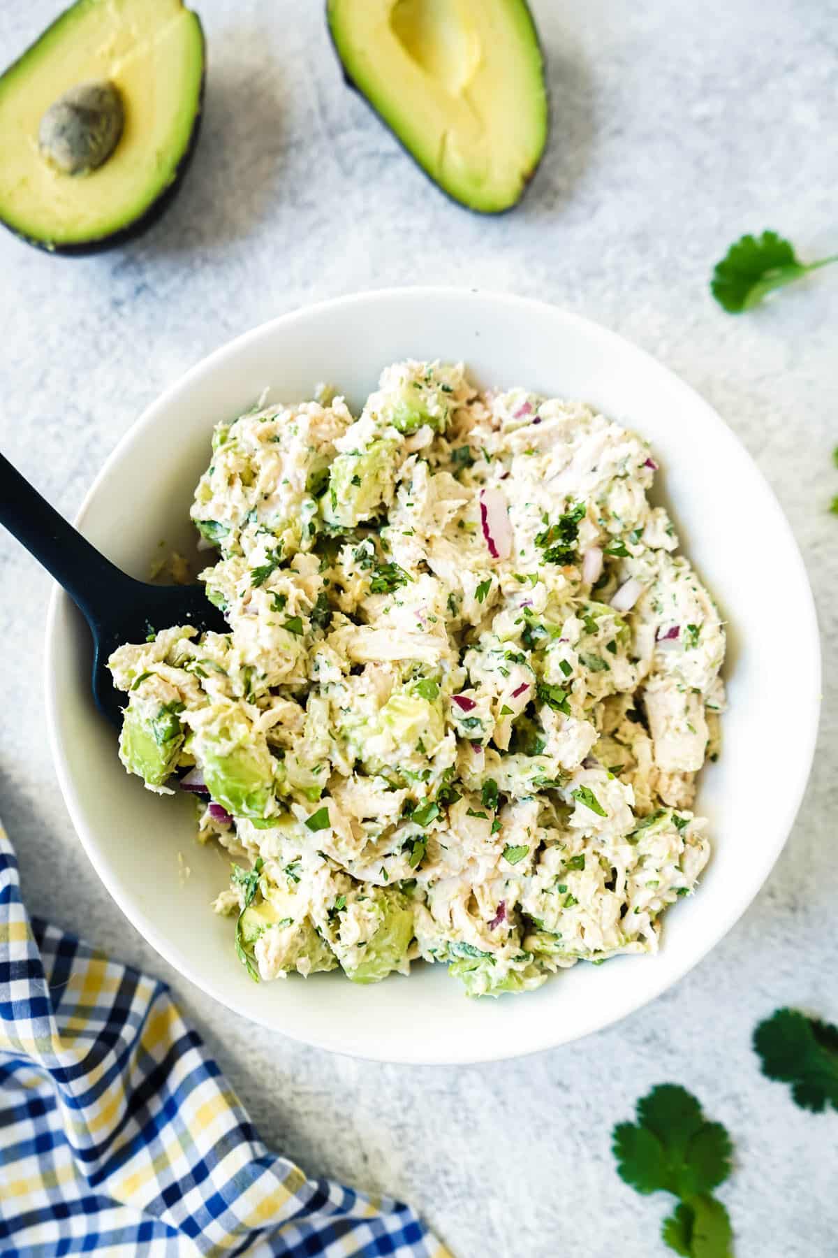 California chicken salad in a white bowl with a spoon.