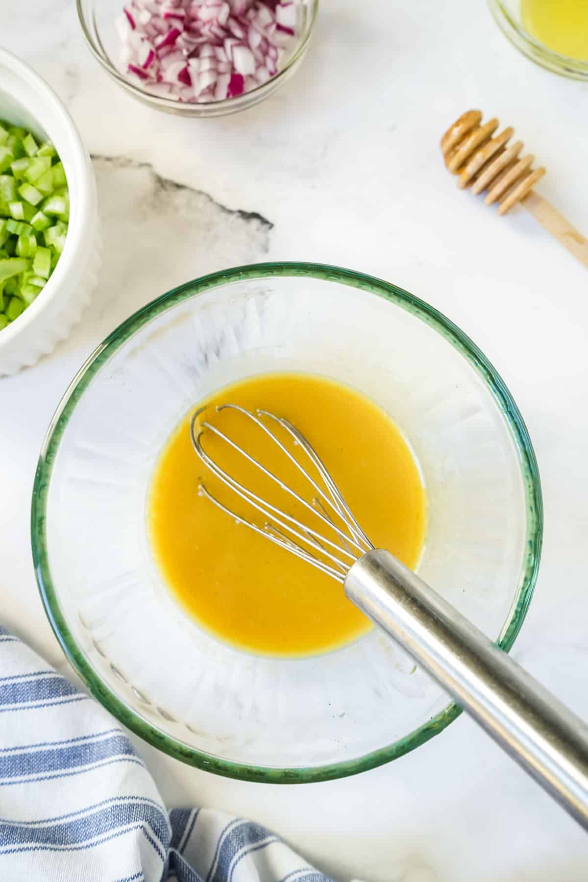 Honey mustard dressing for the chicken salad in a small bowl with a whisk. 