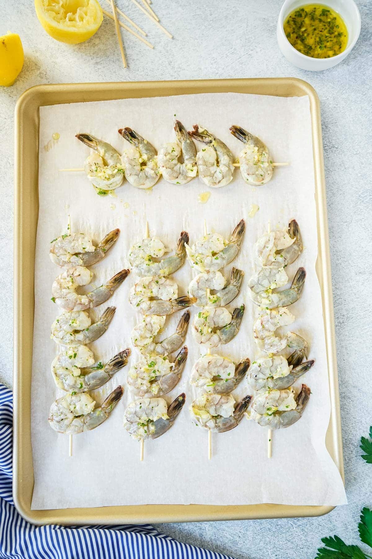 Shrimp skewers on a baking sheet before being baked.