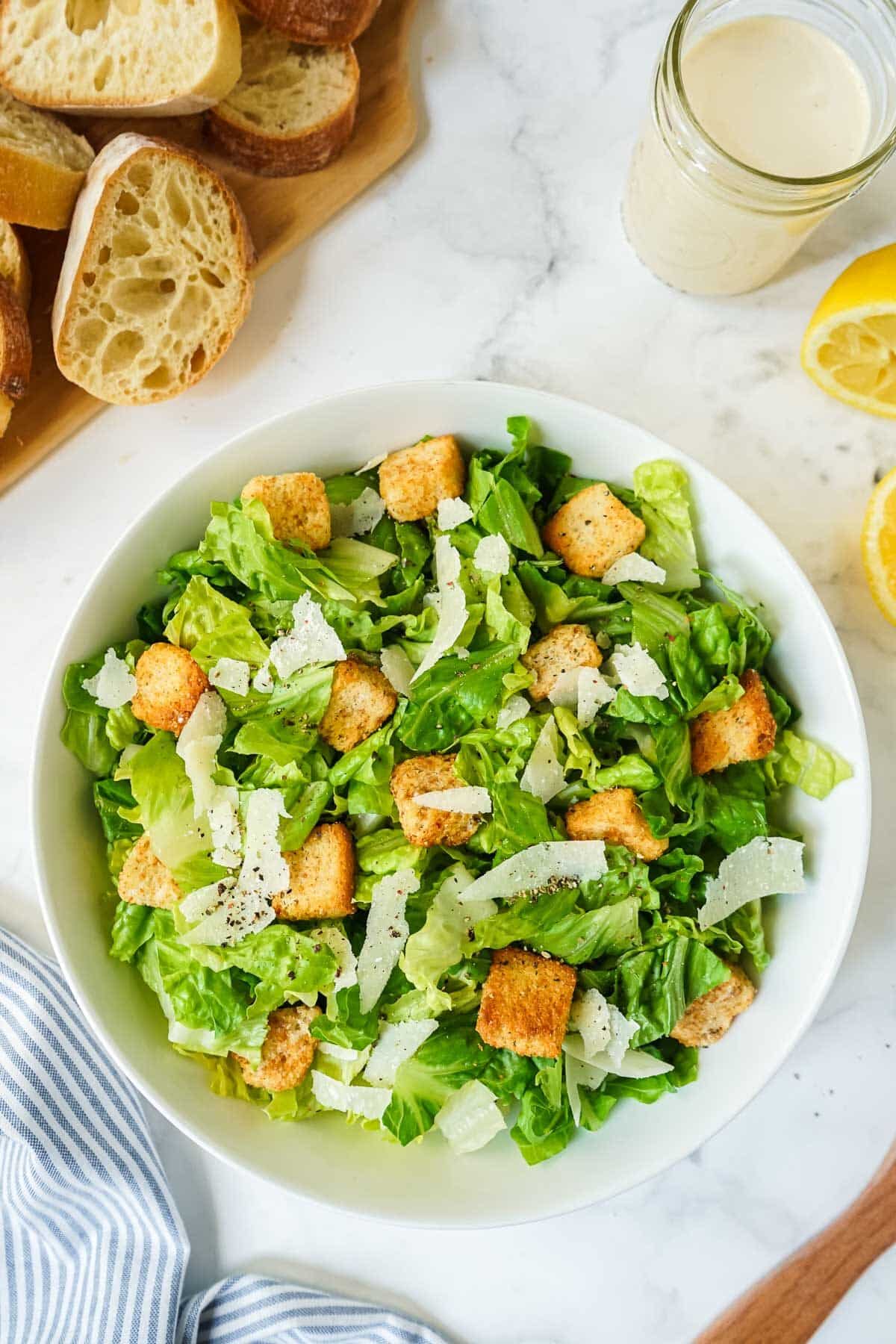 A bowl of Caesar salad that has no dressing on it yet.