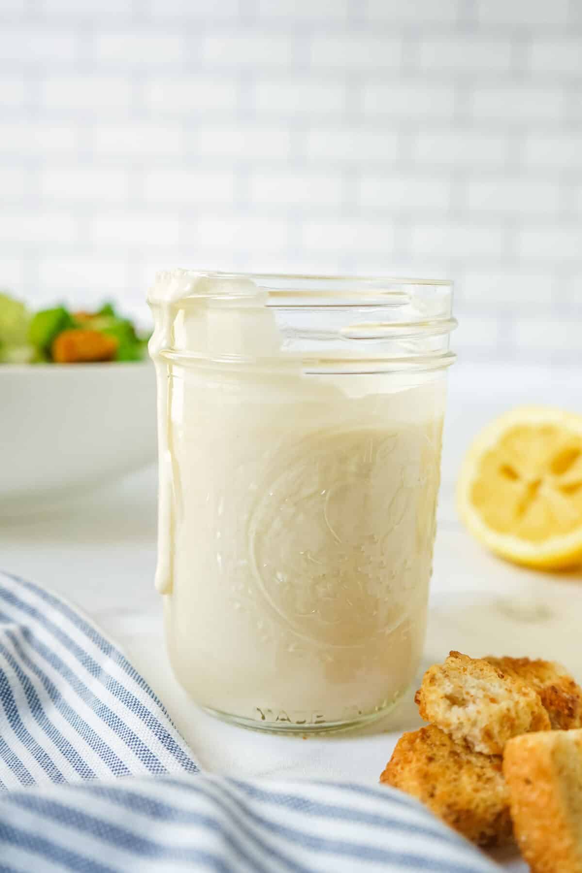 A mason jar with caesar salad dressing made without anchovies.