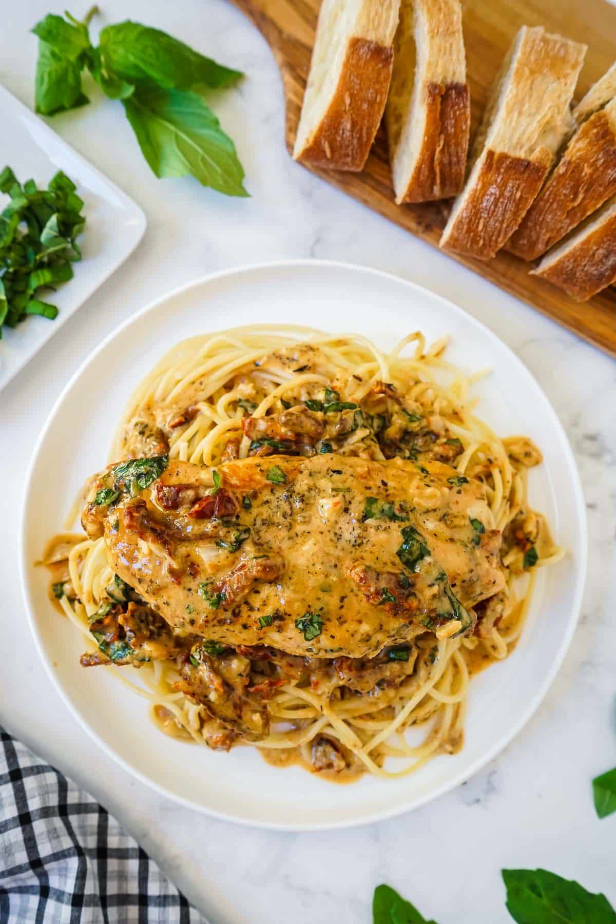 Marry Me Chicken Recipe on a white plate with spaghetti pasta.
