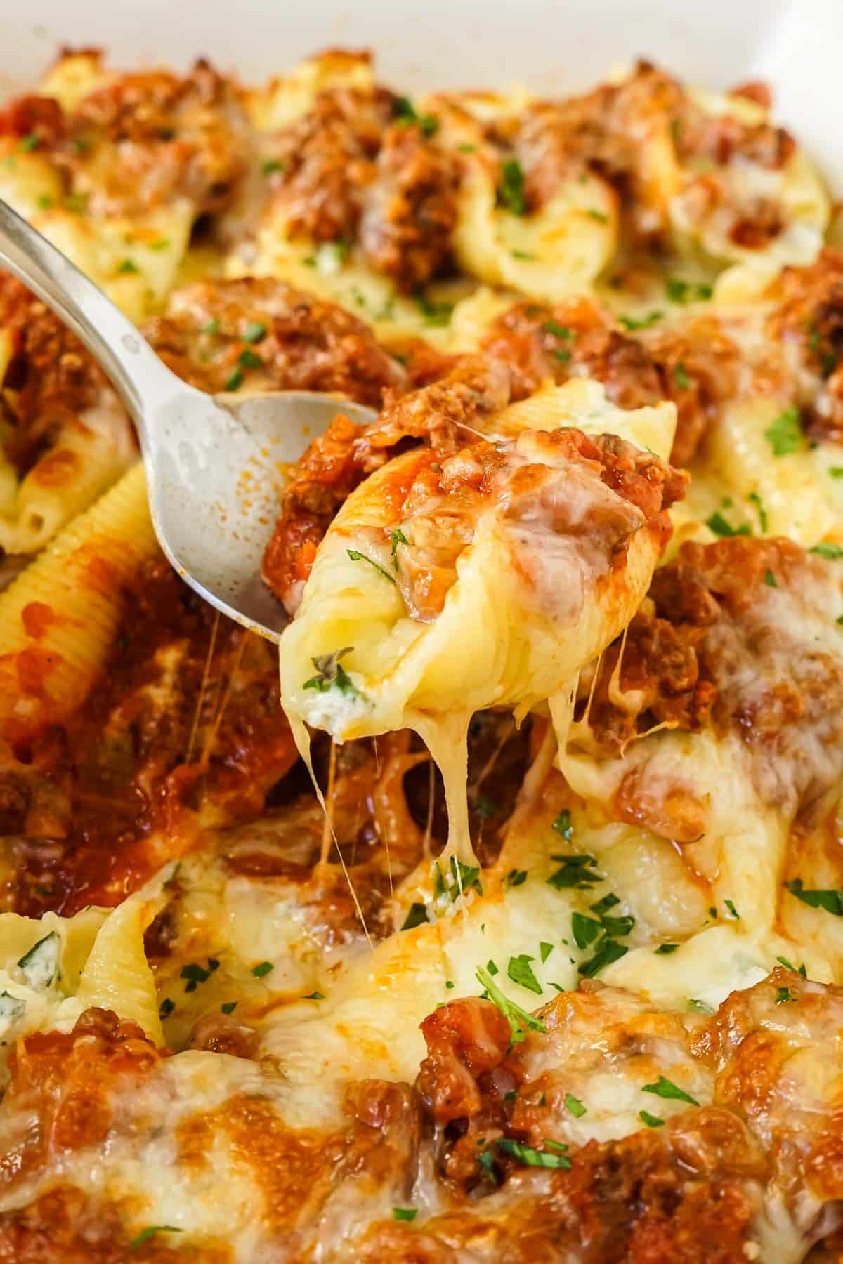 Close up of the beef stuffed shells with a cheese pull.
