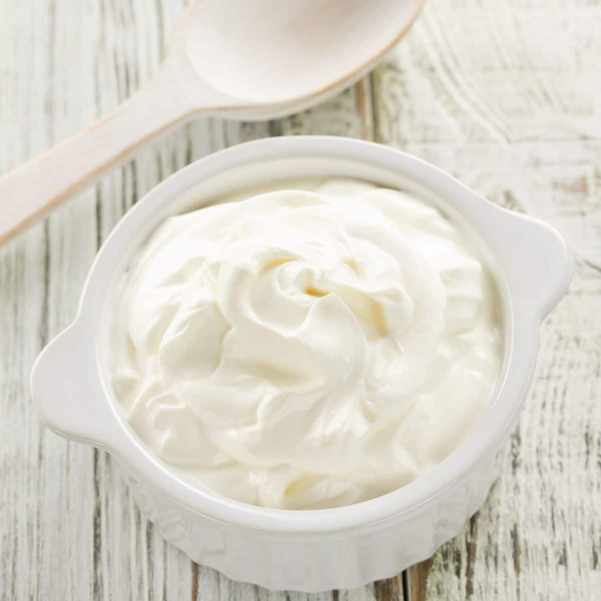 Sour cream in a small white dish.