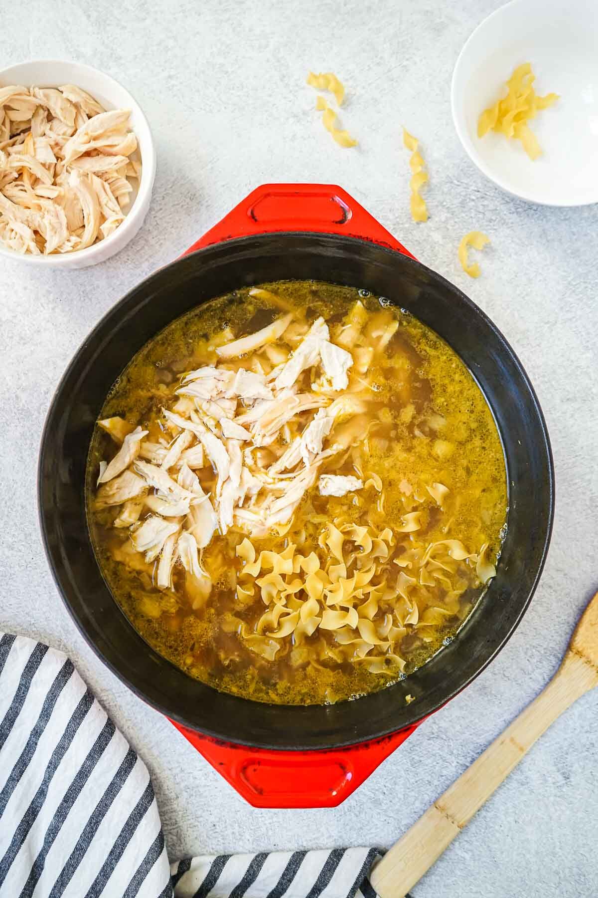 Chicken stock, chicken and noodles in a large dutch oven.