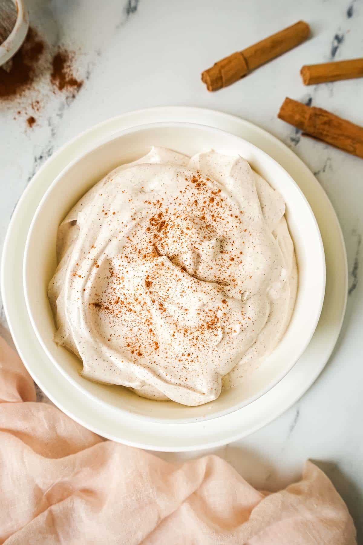Homemade Cinnamon Whipped Cream in a white bowl. 