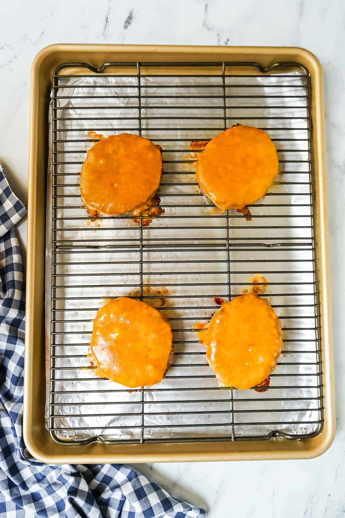 Cooked burgers with cheese on them.