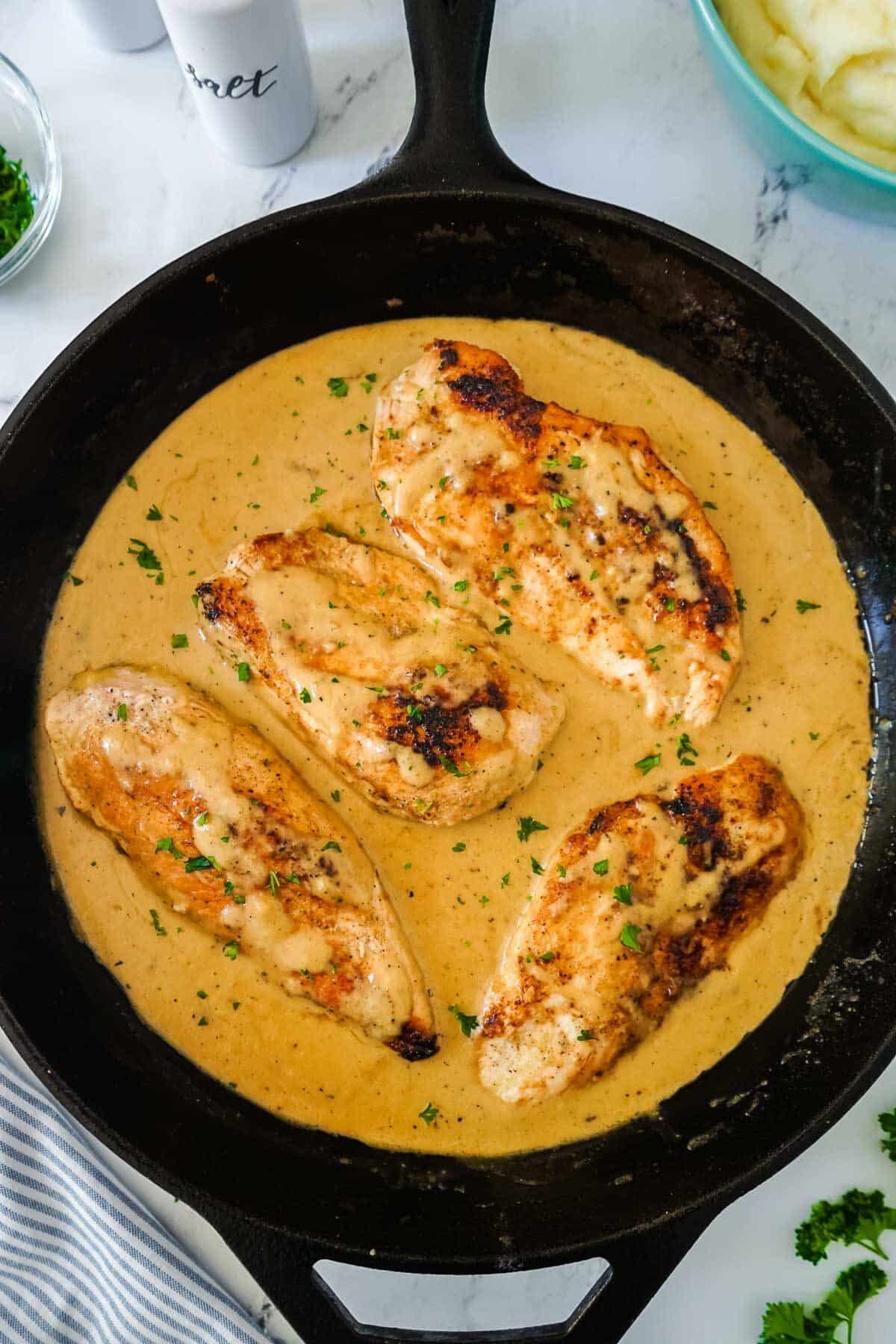 Creamy chicken cooked in a cast iron pan with the  sauce. 