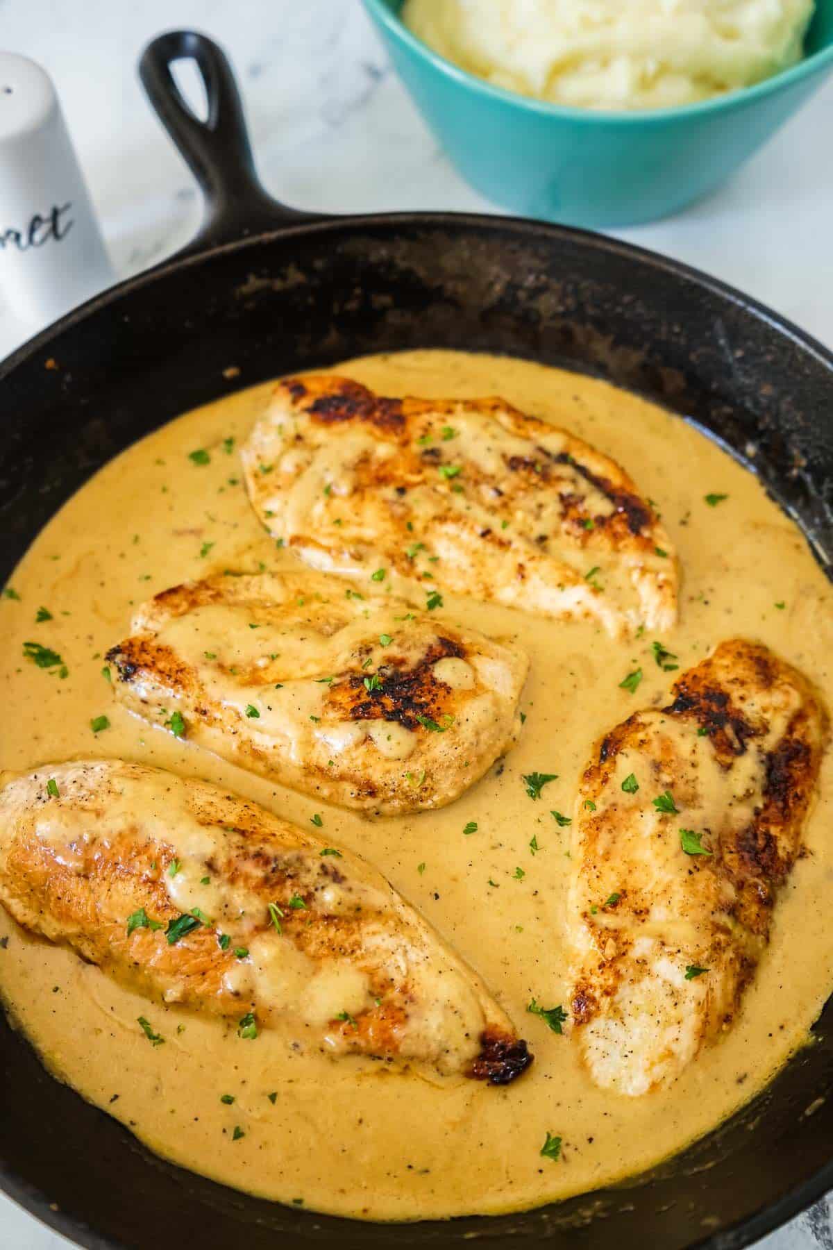 Creamy chicken in a pan with the sauce.