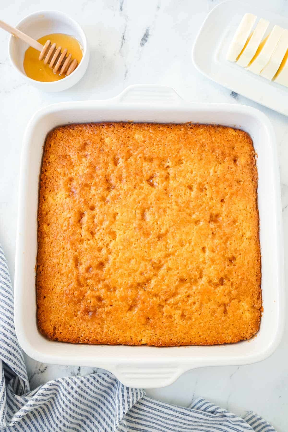 Sweet Jiffy cornbread in a white baking dish after being baked.