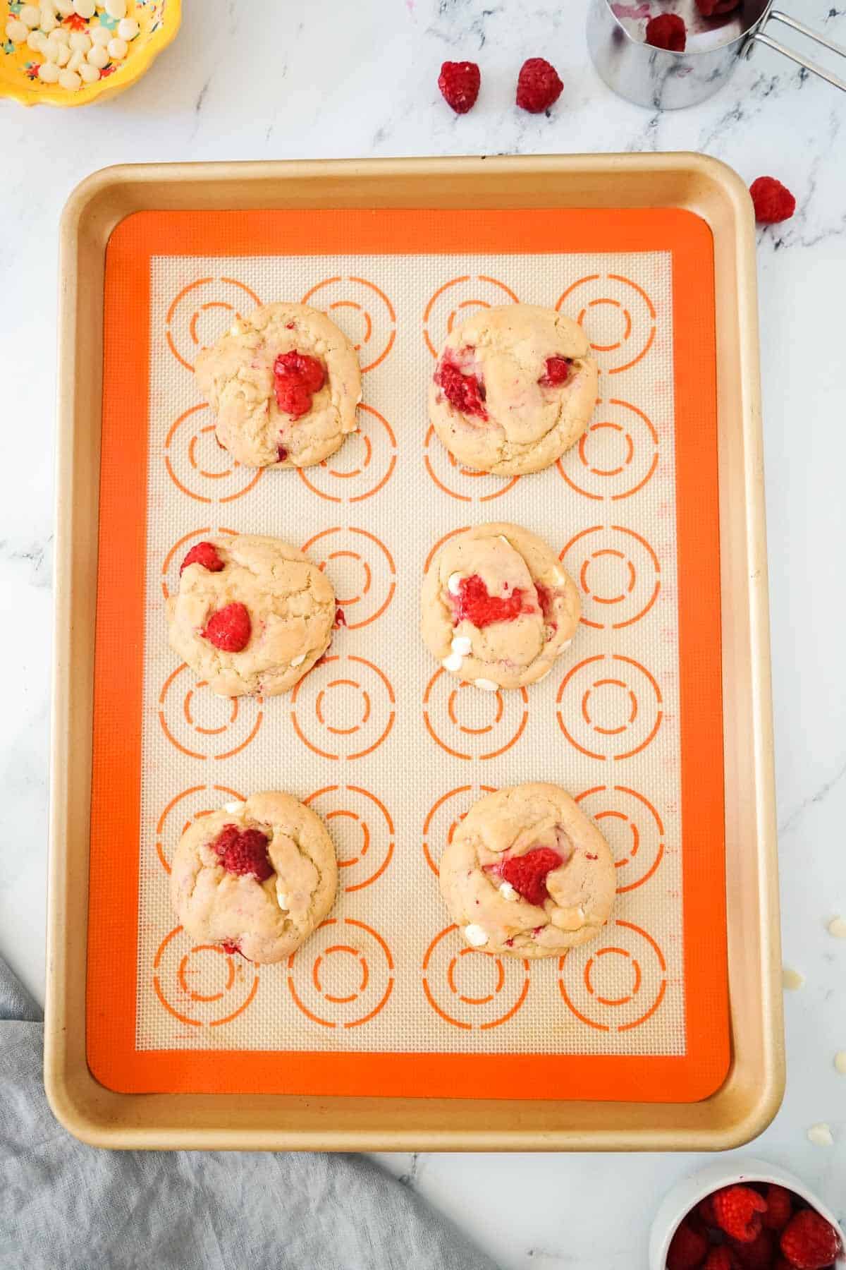 White Chocolate Raspberry cookies on a baking sheet after being baked.
