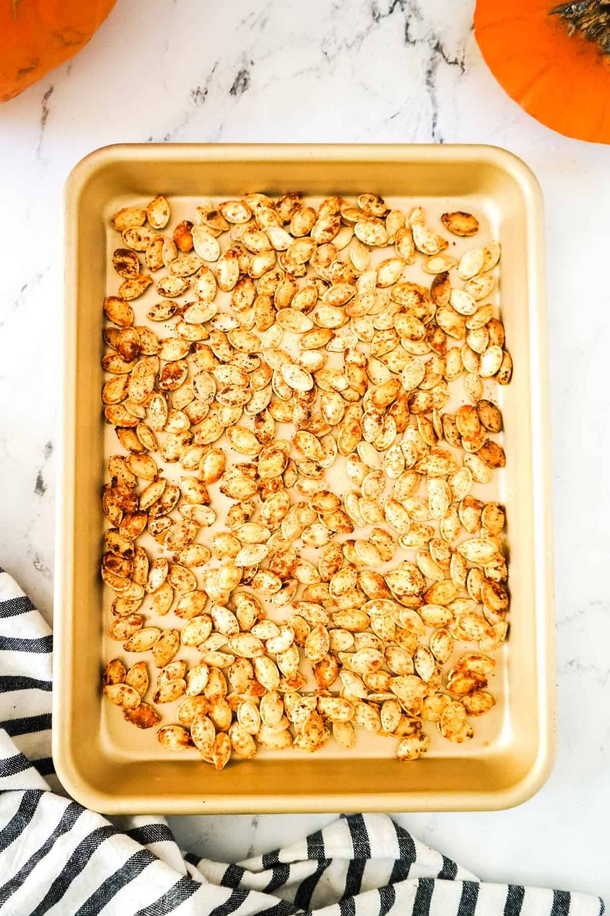 Smoked pumpkin seeds after being smoked on a baking sheet.