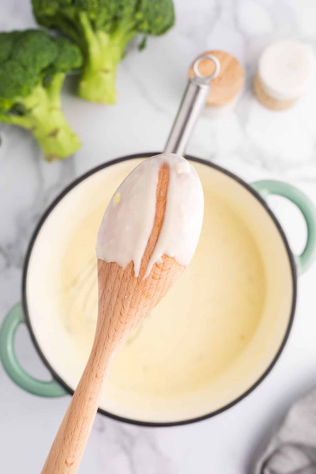 Béchamel sauce coating the back of a wooden spoon.