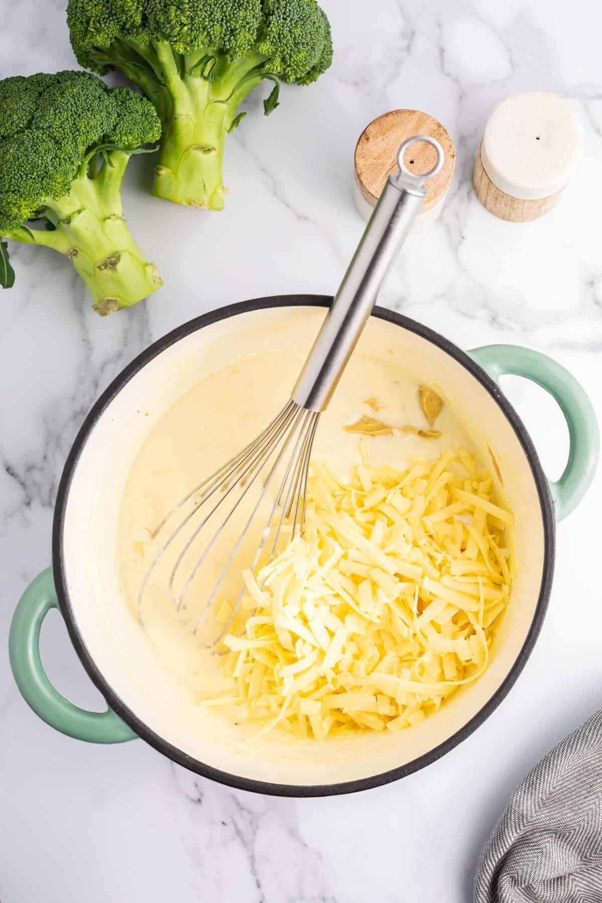 Cheesy and dijon mustard being added to the cheese sauce.