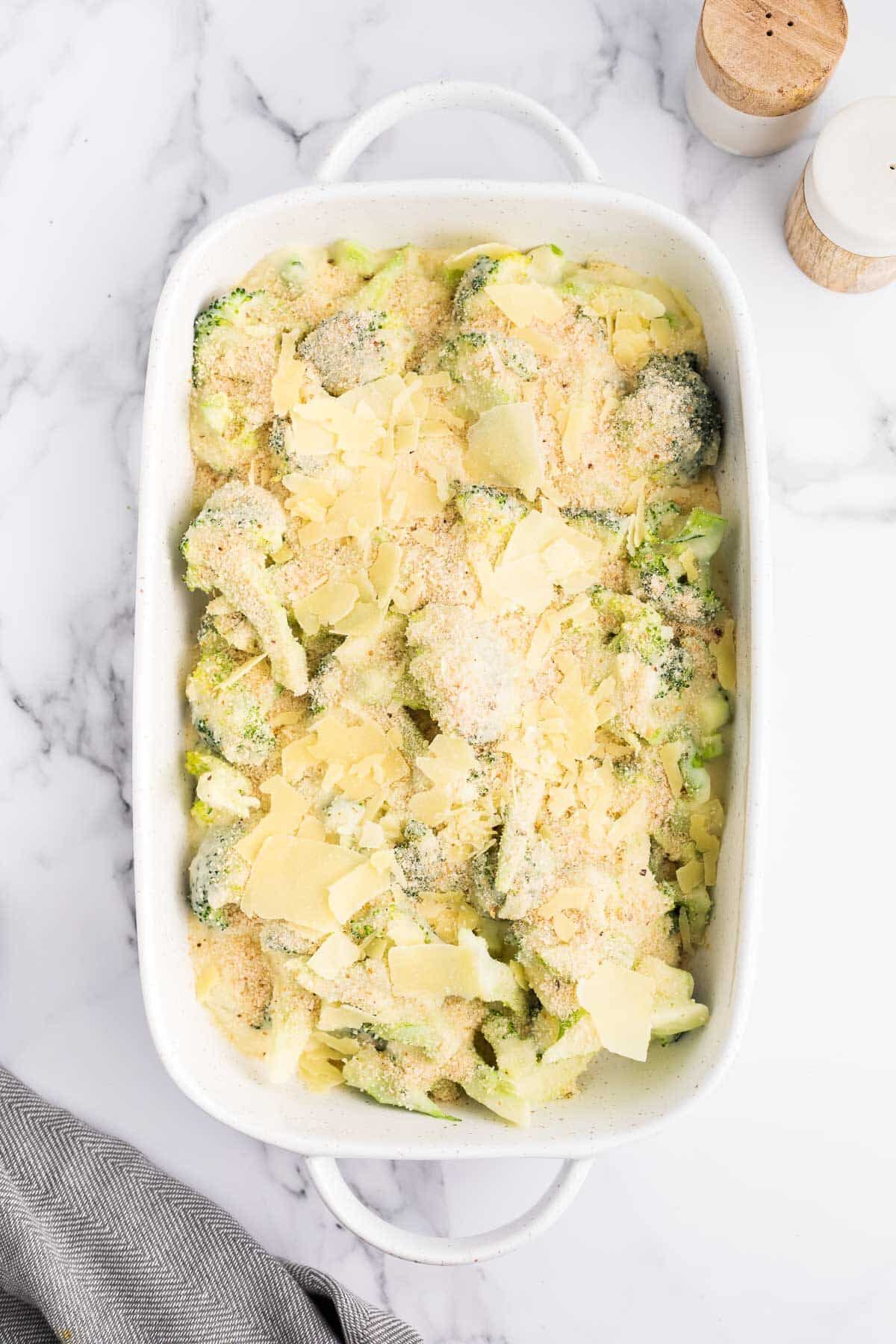 Cheesy Broccoli Au Gratin in a white casserole dish before being baked.