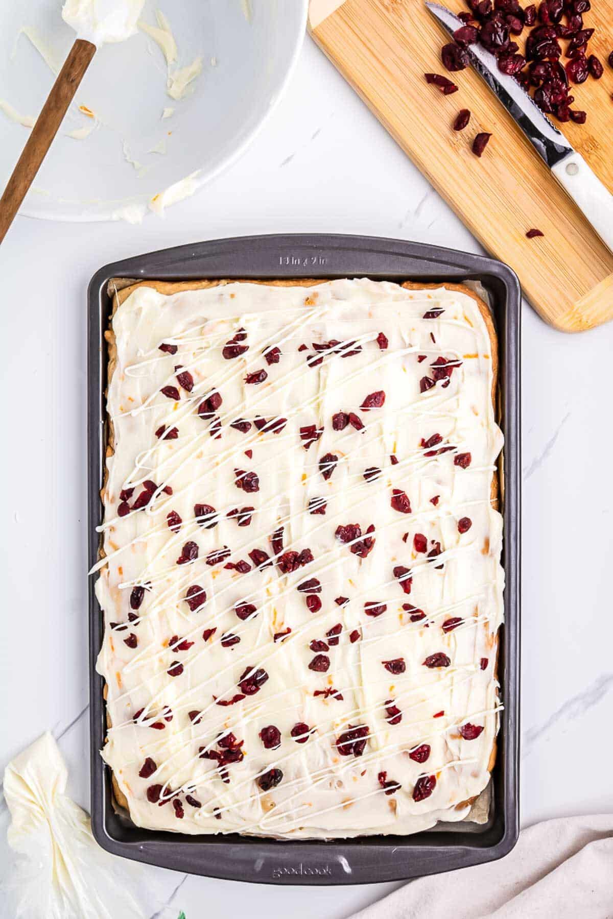 Finished bars with cranberries sprinkled on top and a little white chocolate drizzle over the top 