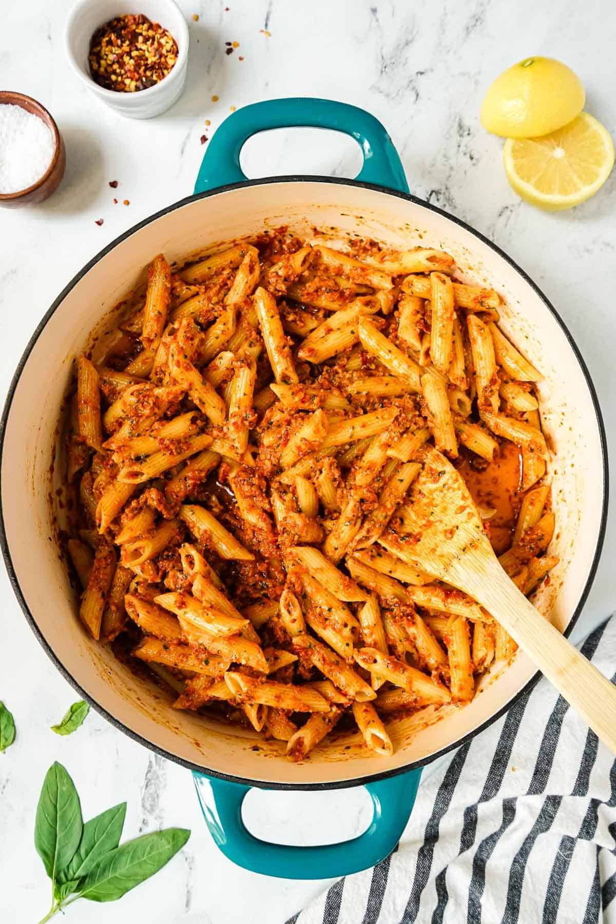 Easy Sun-Dried Tomato Pesto Pasta  in a large skillet with a wooden spoon.