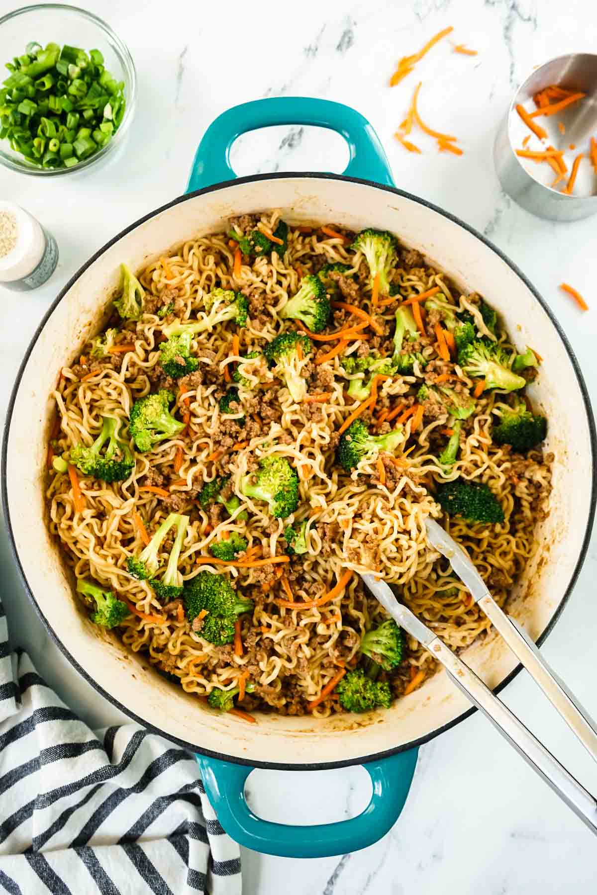 Ground Beef Noodle Stir Fry in a large. pan with tongs. 