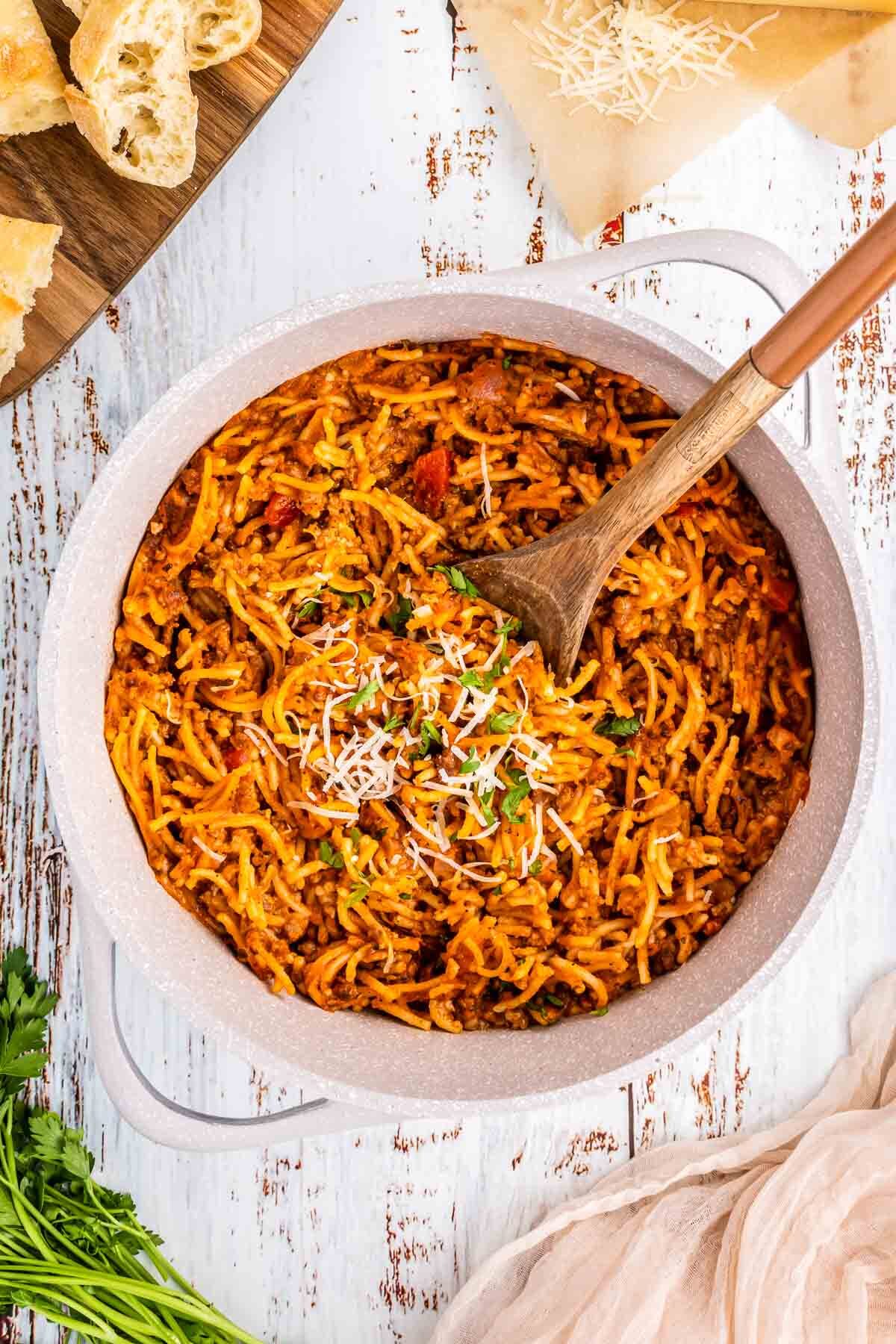 One pot spaghetti on a large pot with a wooden spoon.