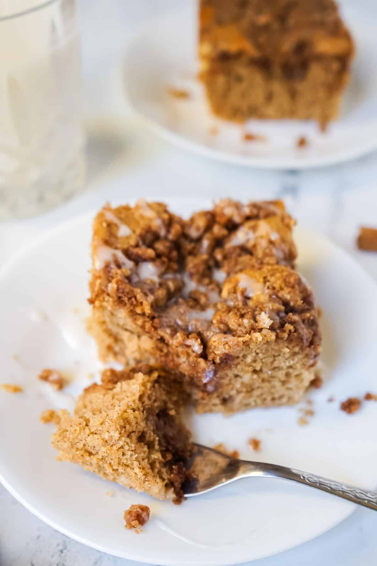 A piece of the coffee cake made with Bisquick on a white plate with a fork.