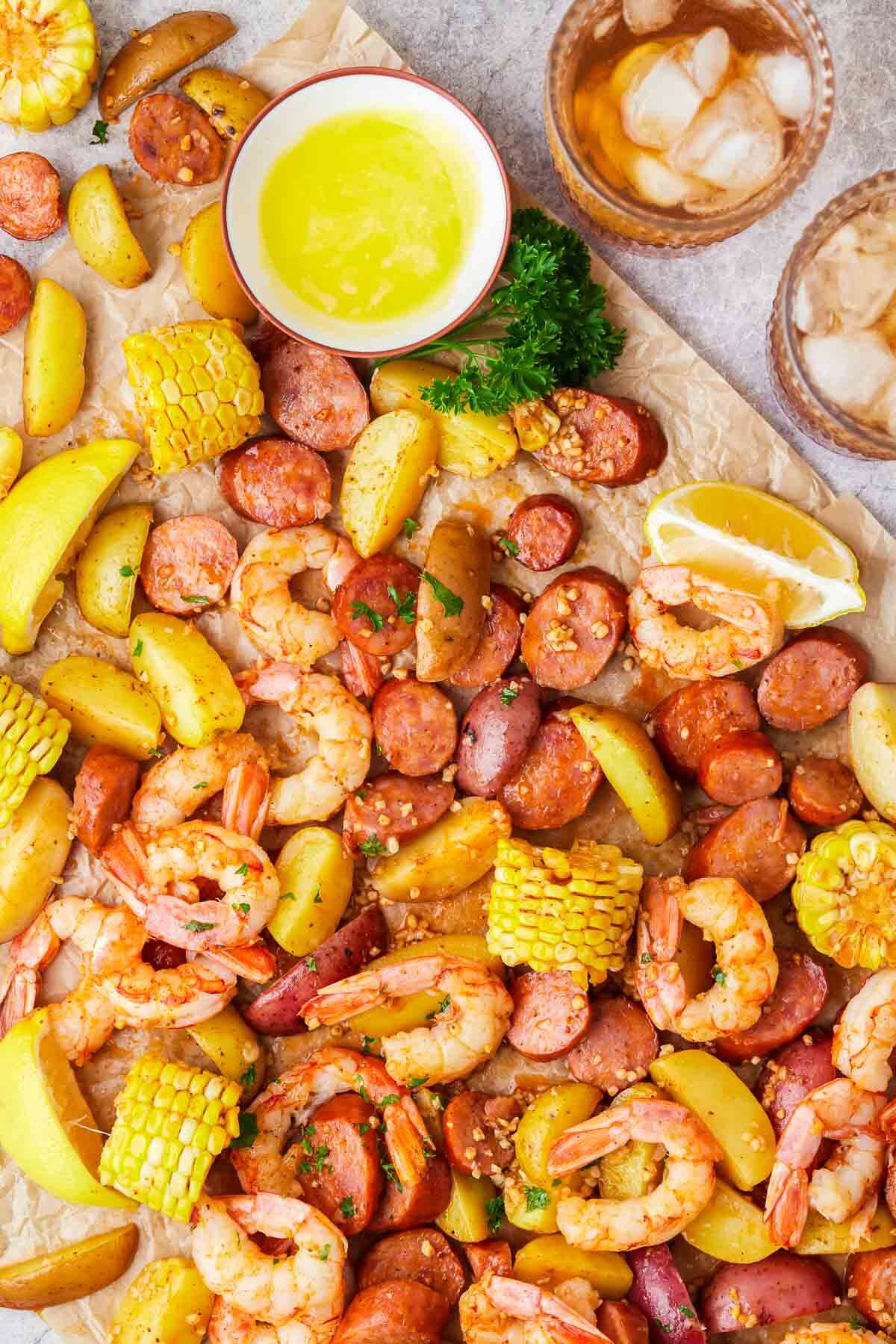 Shrimp boil that has been baked and being served on parchment paper.