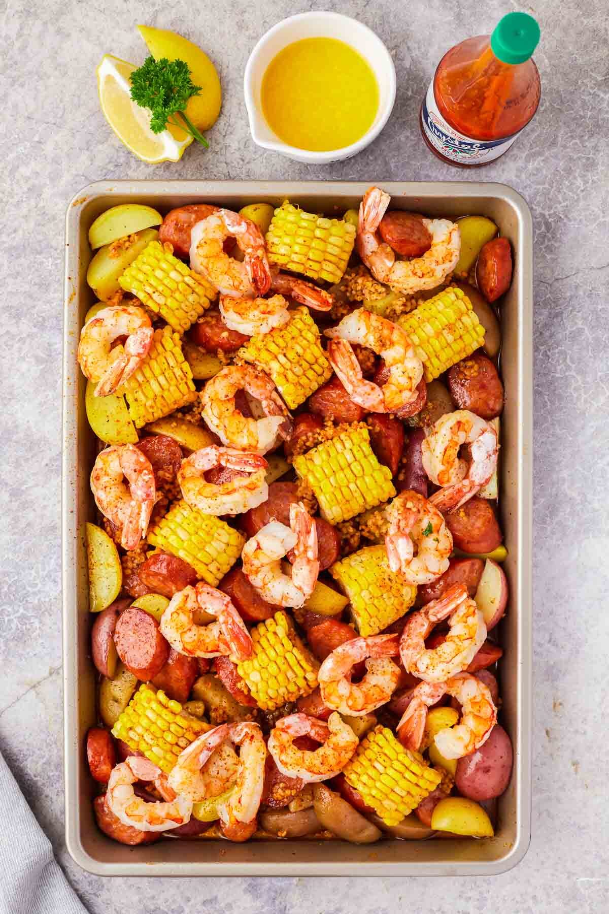 Sheet pan shrimp boil cooked in the oven with shrimp, sausage corn and potatoes.