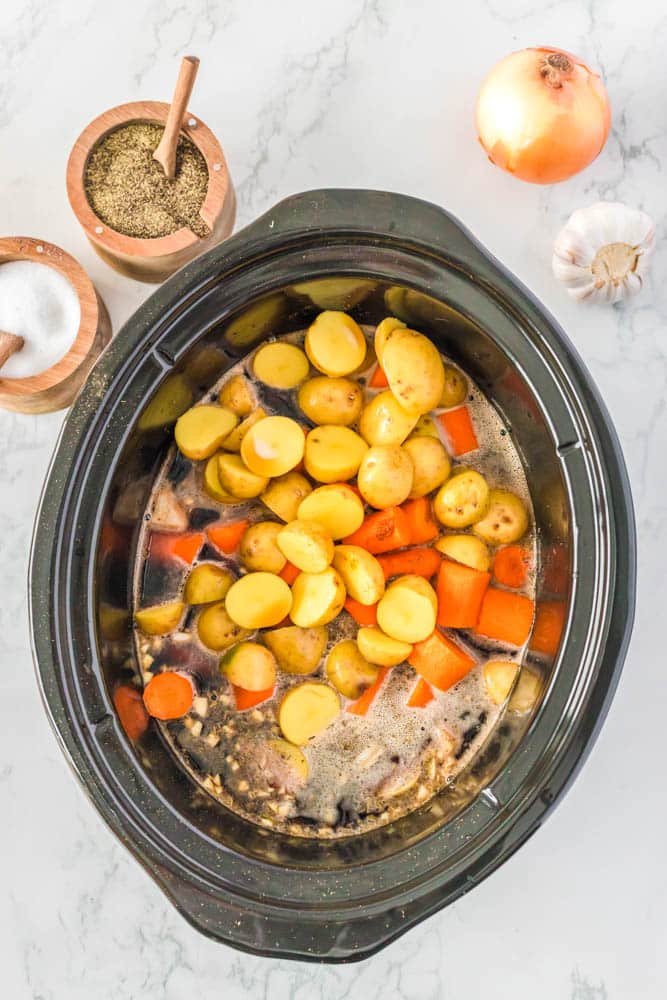 Irish Stew in the slow cooker with veggies and broth added,