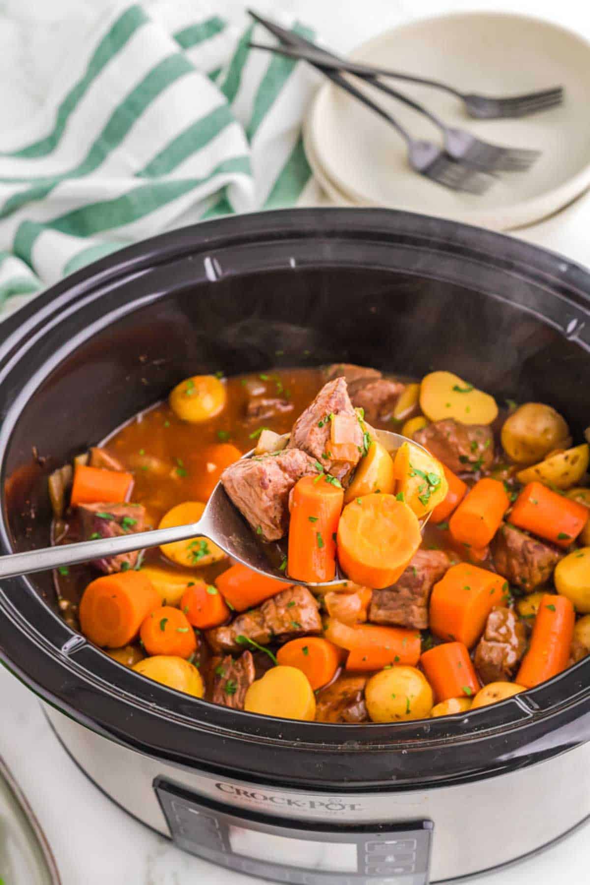 Slow Cooker Irish Stew with Guinness on a spoon in a slow cooker.