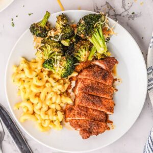 oven baked pork chops, macaroni and cheese, and broccoli on a white plate