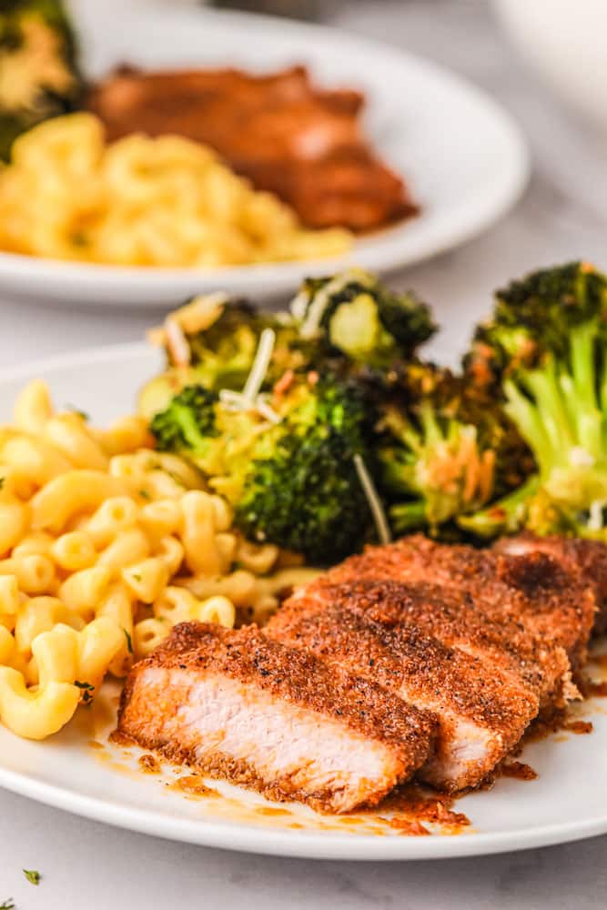 pork chop, mac and cheese, and broccoli dinner on a white plate