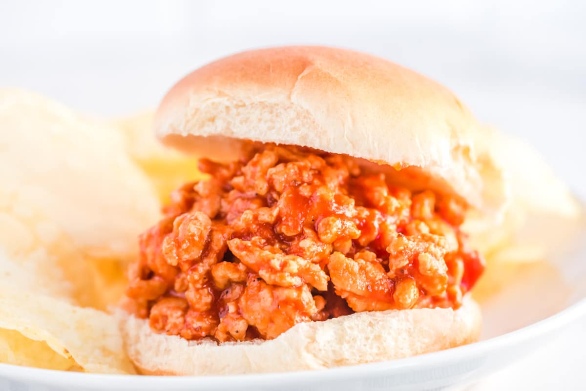 Ground chicken sloppy joe on a plate with potato chips.