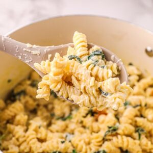 serving ricotta and lemon pasta with spinach on a spoon