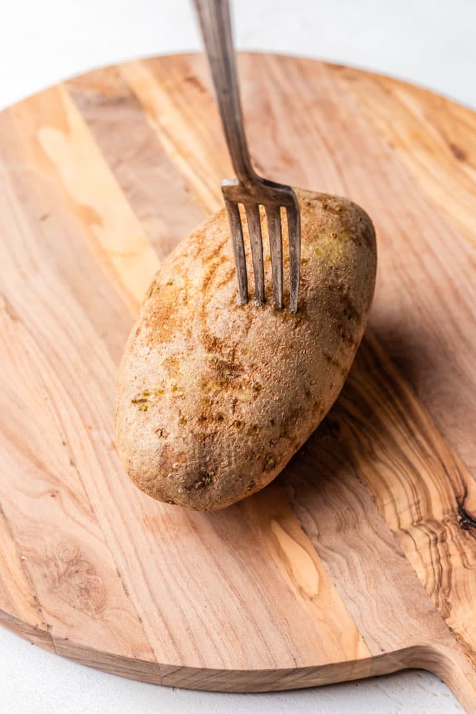 A baked potato being pierced with a fork