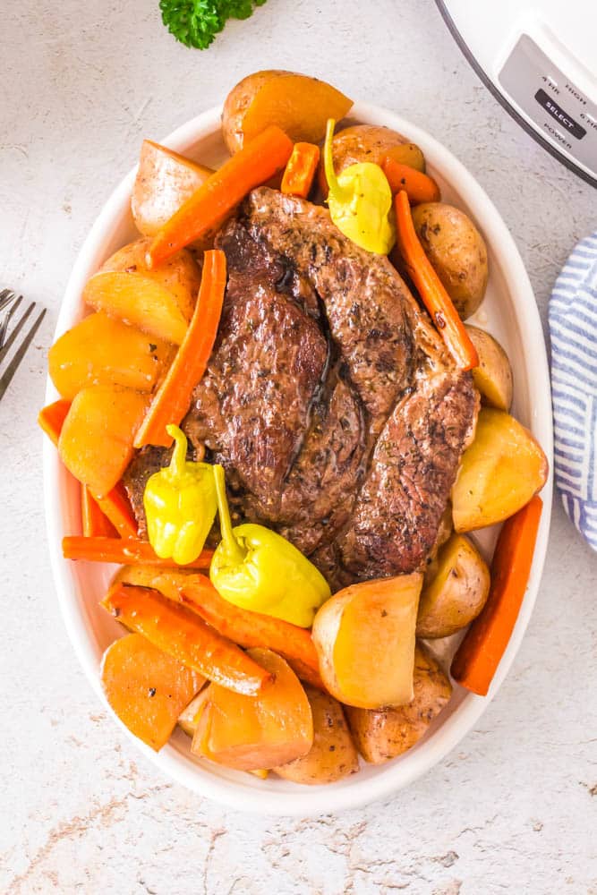 Mississippi Pot Roast with Potatoes and Carrots on a white serving dish.