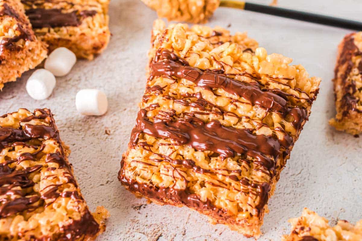Peanut butter rice krispie treats drizzled with chocolate.