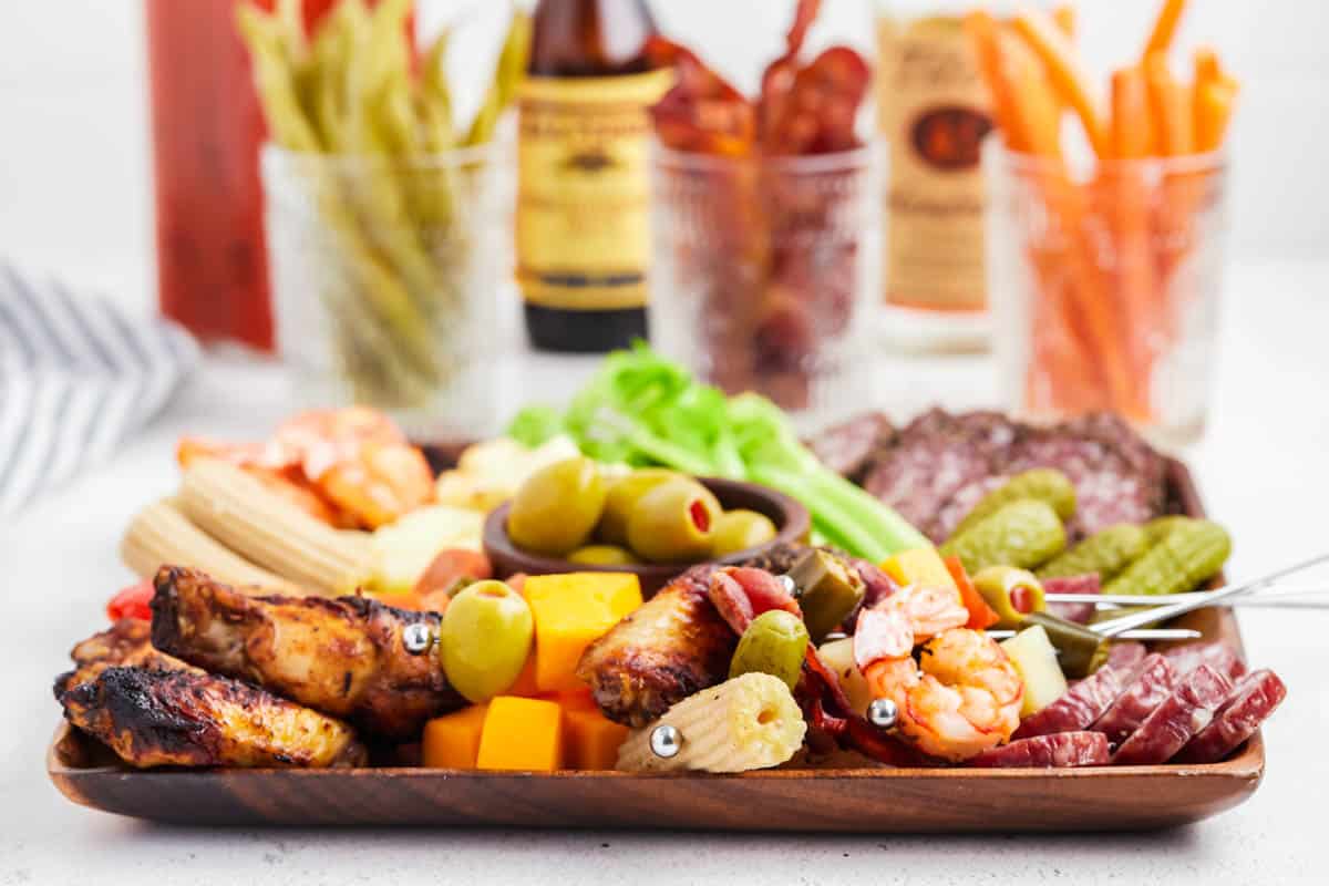 Bloody Mary Garnishes on a wooden charcuterie board. 