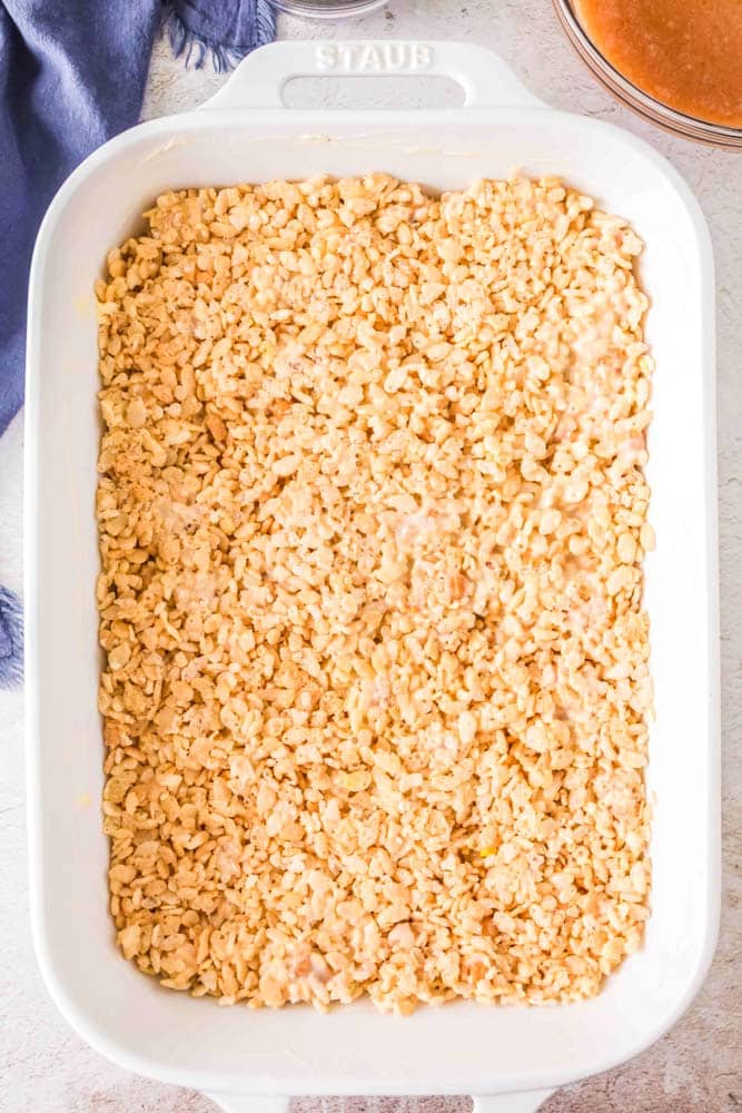 Rice Krispie cereal mixture with marshmallows spread in a white pan.