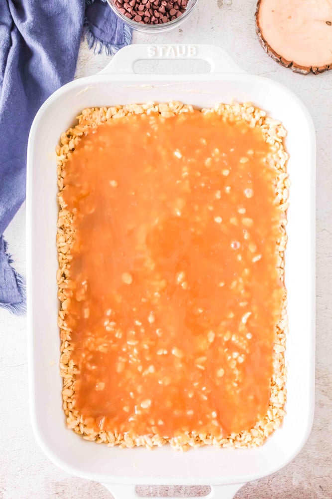Rice krispie cereal mixture with caramel poured on top.