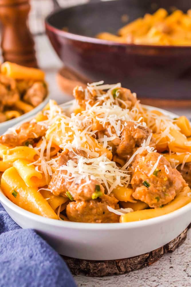 Spicy Italian Sausage Pasta in a bowl garnished with grated Parmesan cheese.