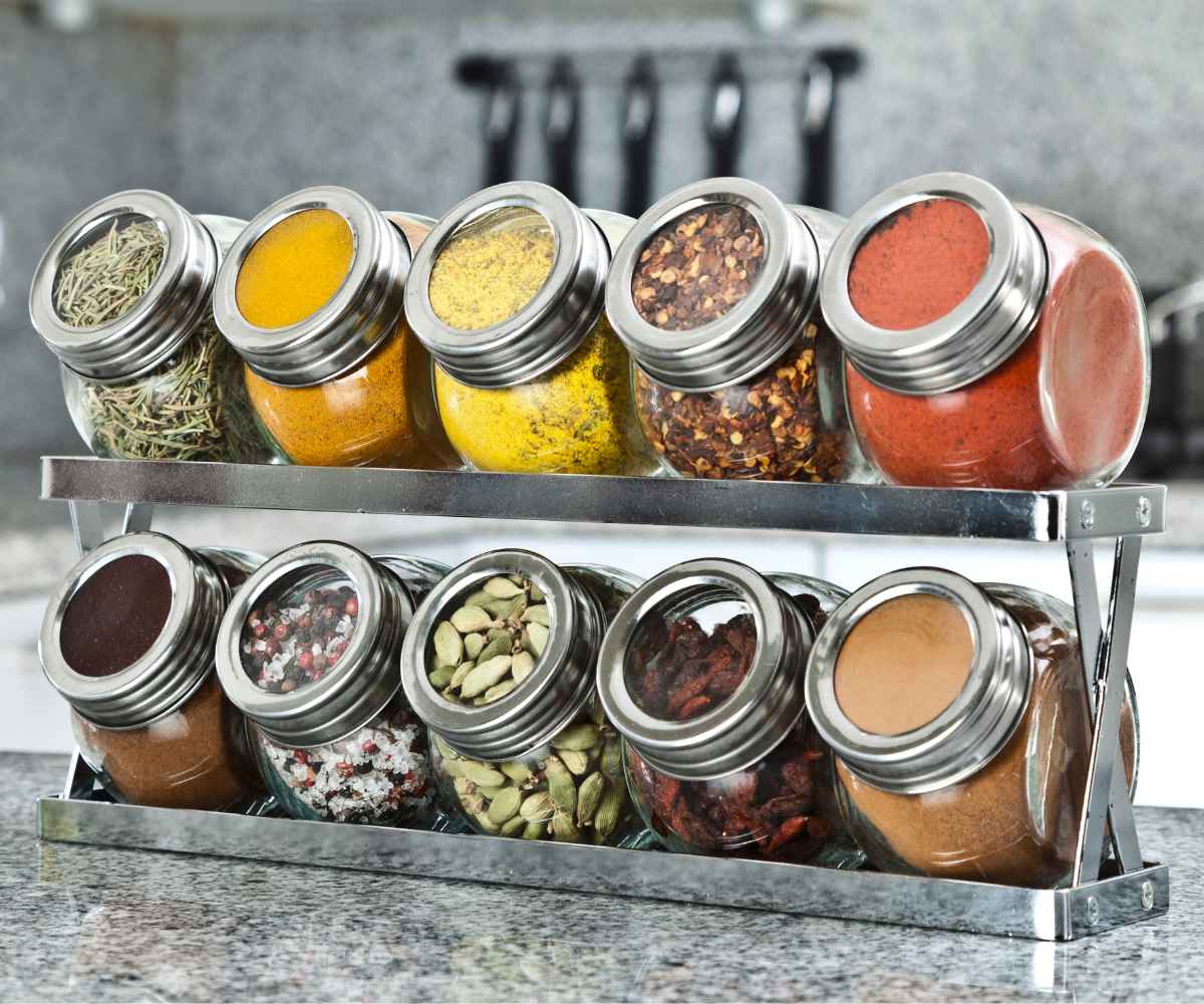 Different spices in small jars on a kitchen counter.