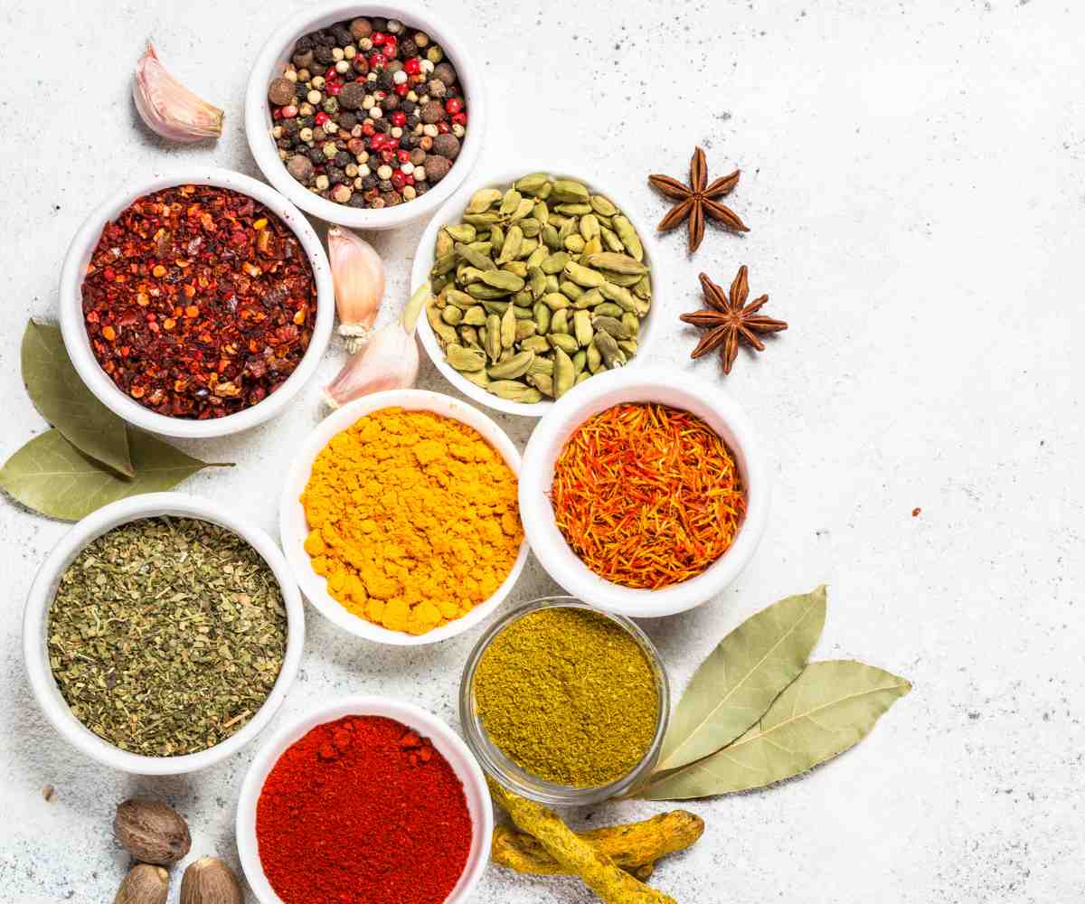 Colorful spices in small white bowls.