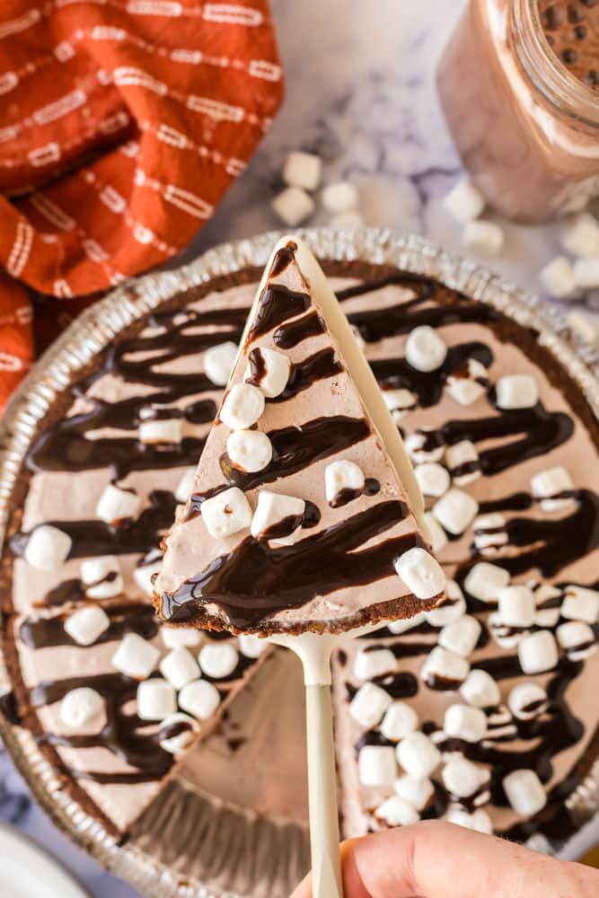 an overhead image of a triangular slice of chocolate pie with chocolate syrup and mini marshmallows