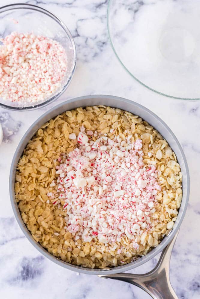 Rice krispie cereal and crushed peppermint candy in a large pot.