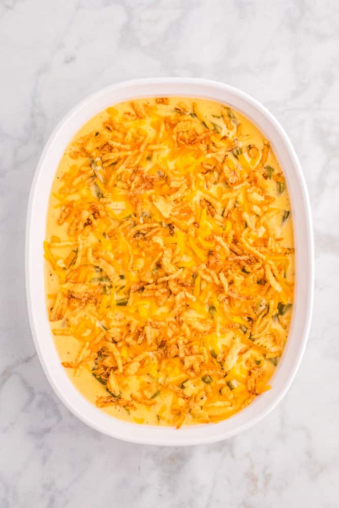 Green Bean Casserole made with Velveeta before being baked in a white dish.