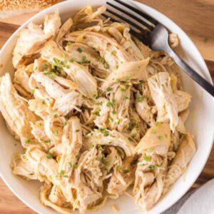 Air Fryer Shredded Chicken in a white bowl with a fork.