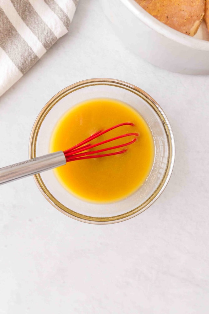 Olive oil and vinegar whisked together in a bowl.