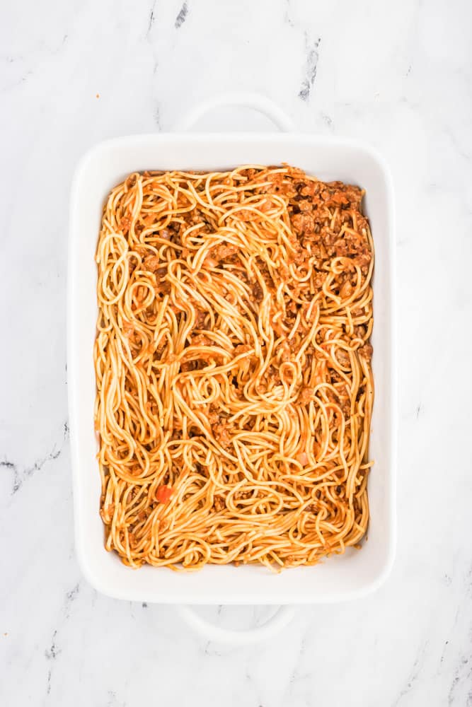 cooked spaghetti and sauce in a white baking dish